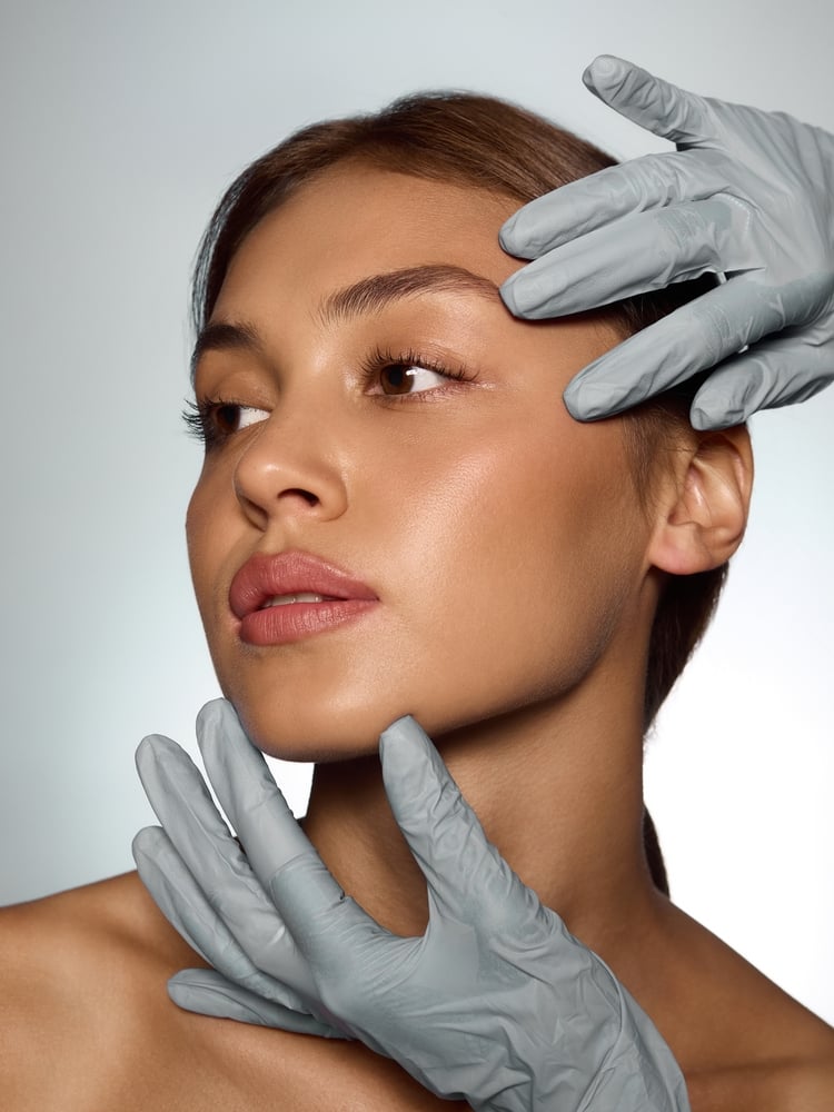 Doctor,Hands,In,Gloves,Examining,Woman,Face,With,Precision,And Facial Balancing With Filler in Boise Idaho