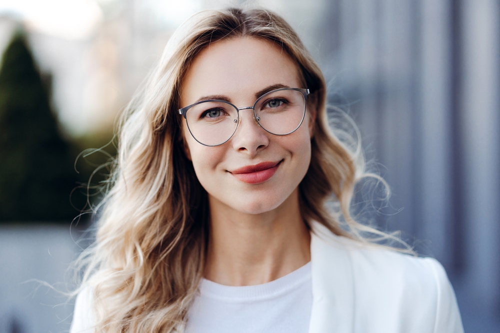 Blonde,Professional,Woman,With,Glasses,Smiling,Confidently,In,Natural,Outdoor Facial Balancing in Meridian, ID for Natural Harmony
